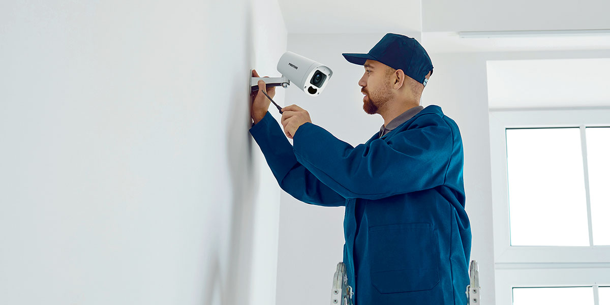 Imagem do curso de instalação de câmeras (CFTV): aluno e instrutor realizando instalação e configuração