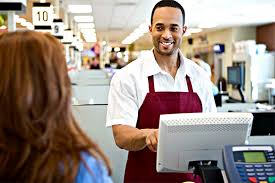 Operador de caixa em supermercado ou loja utilizando sistema de pagamento